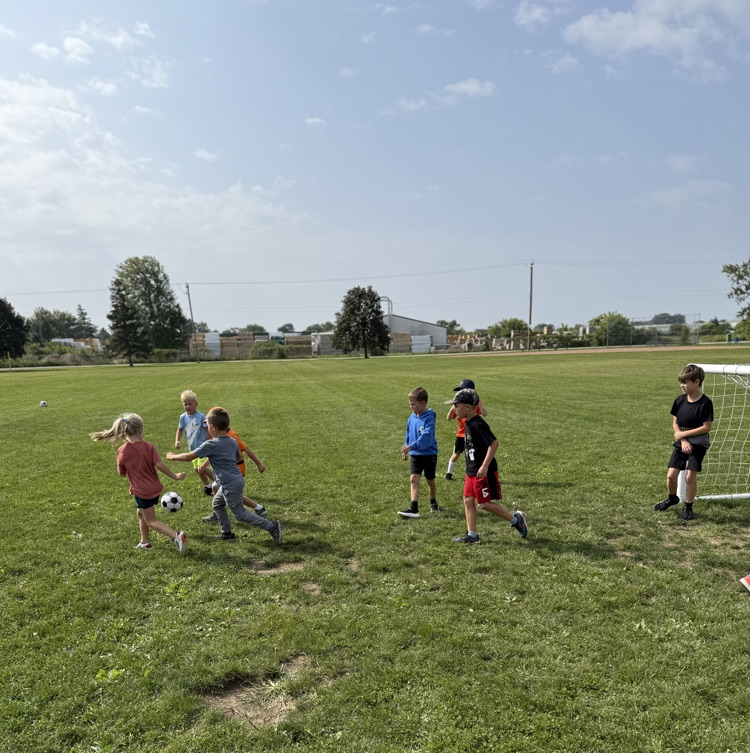 grade 1-2 students playing soccer