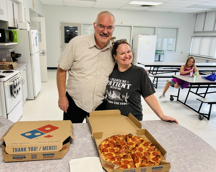 Trustee Short and School Council Member handing out pizza with smiles