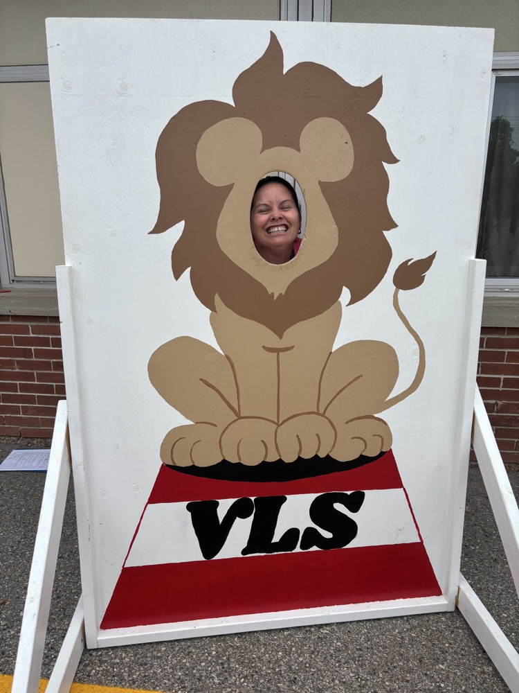 Teacher with her head in a cut out lion picture