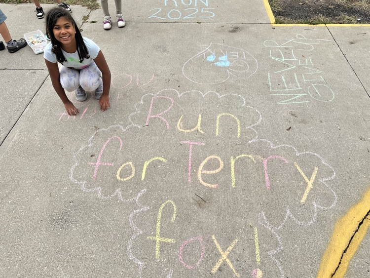 Child sitting beside sidewalk chalk drying for Terry Fox run