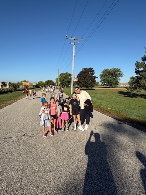a group of girls standing with a Mom smiling for the camera for our Terry Fox Run today
