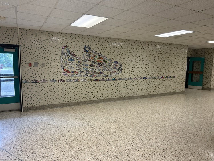 students from four classes decorated a paper shoe and they are displayed in the hallway  