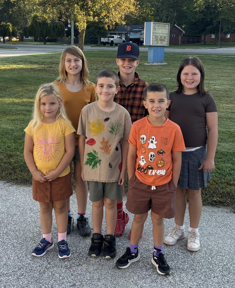 6 students standing and smiling at the camera wearing fall colours