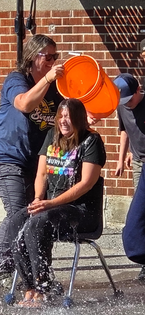 bucket of water being dumped on a teacher by students 