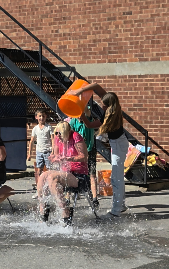 bucket of water being dumped on a teacher by students 