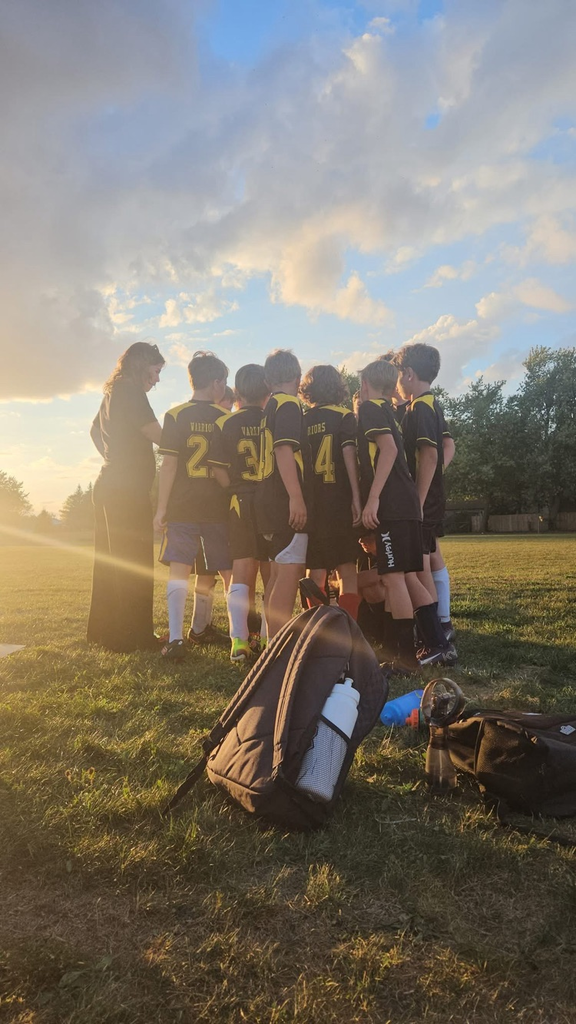 boys, soccer team huddled together in the late afternoon sun