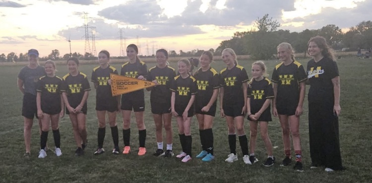 Girls, soccer team, smiling for the camera with their second place banner