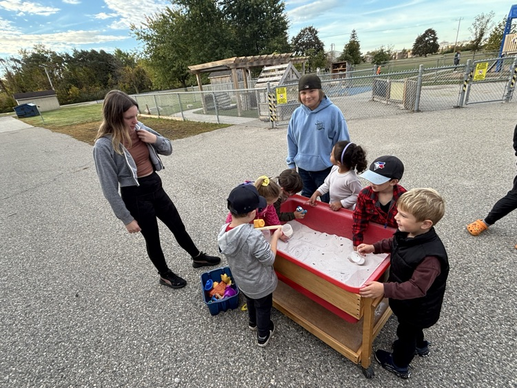 A group of students playing in the sandbox