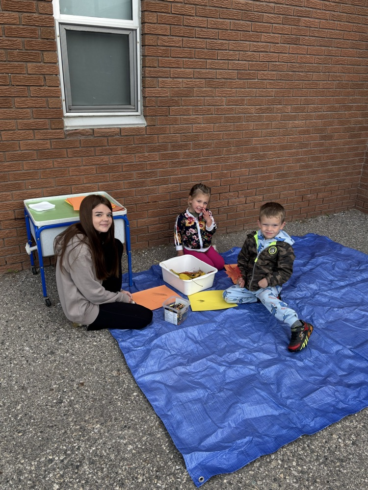 An older student sitting with two younger students