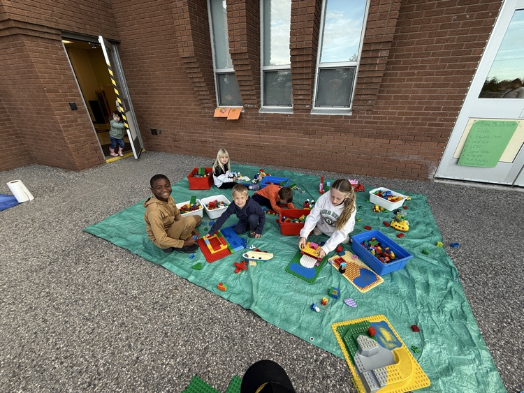 A group of students playing at the Lego station