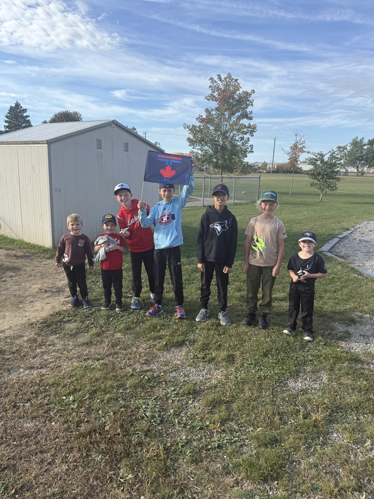A group of students standing outside during their nature hunt smiling at the camera