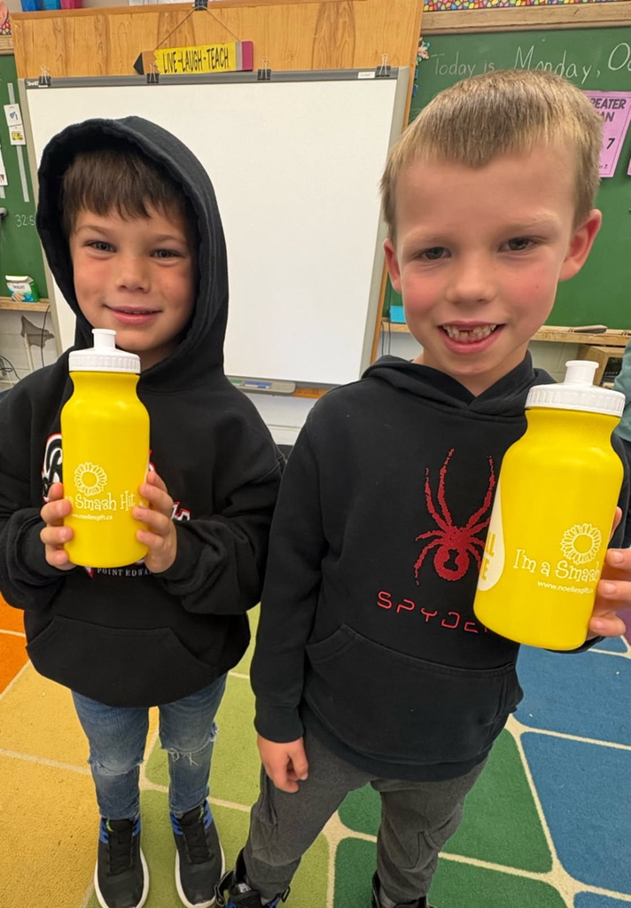 two students holding yellow water bottles 