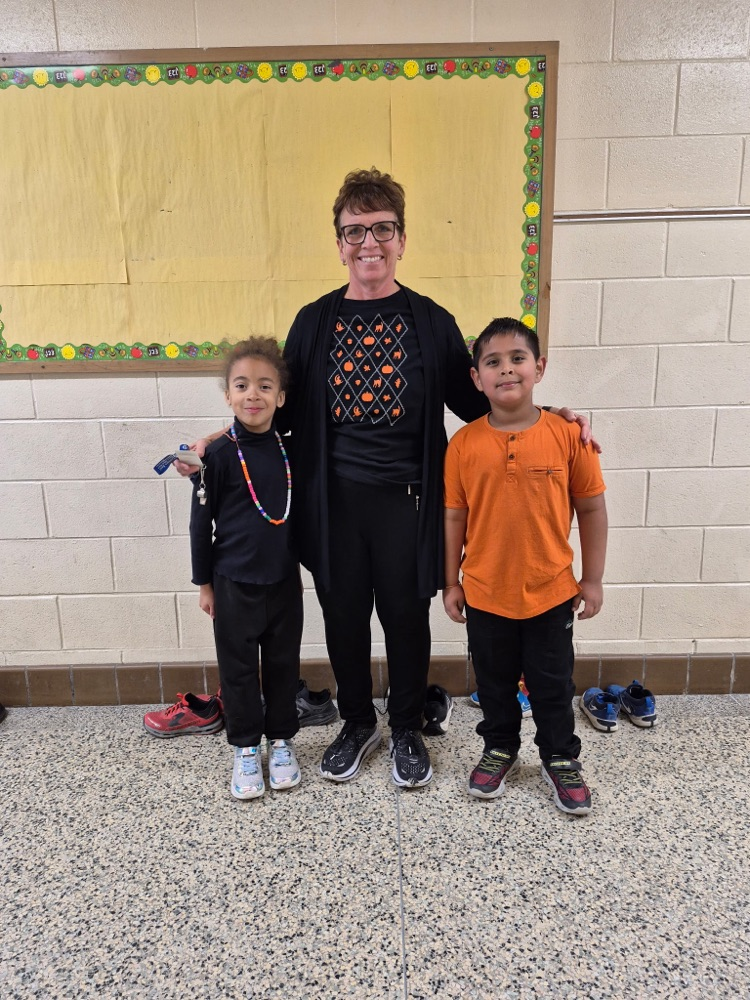 students and teacher wearing orange and black 