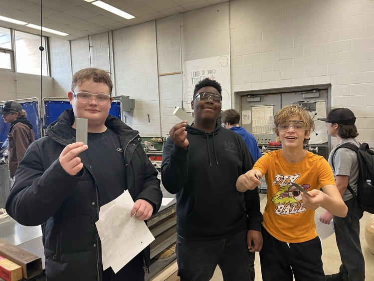 student showing off products they made in a