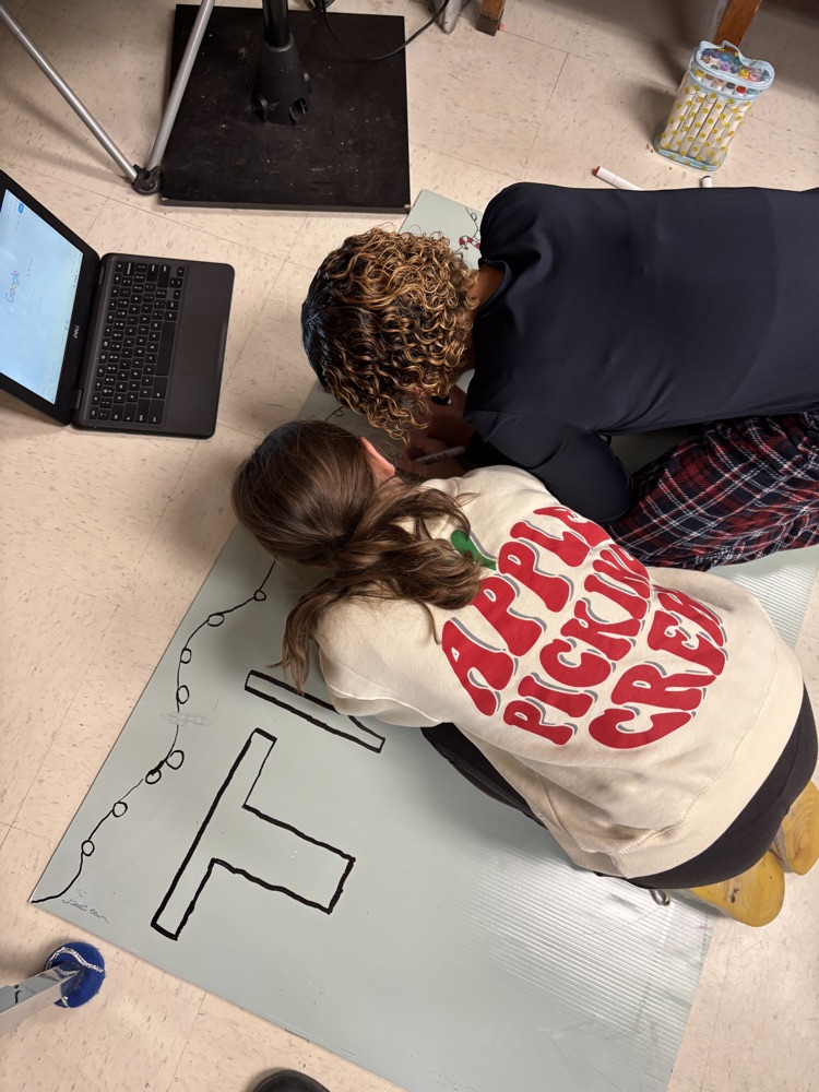 students on the floor working on a poster