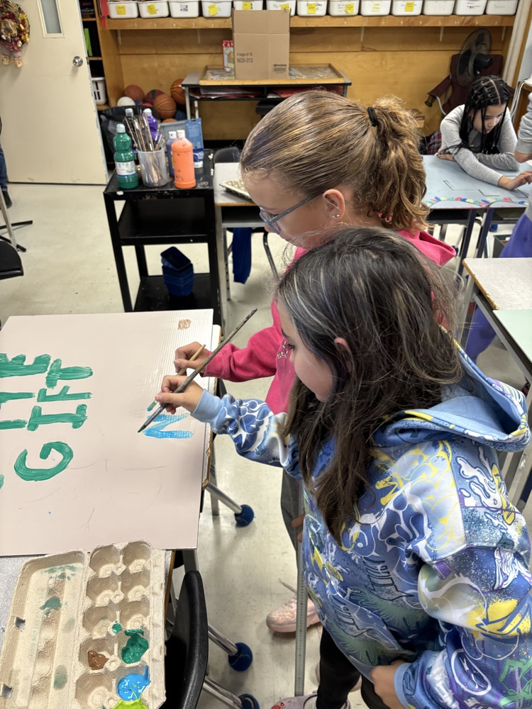 Students painting a poster to advertise an upcoming event