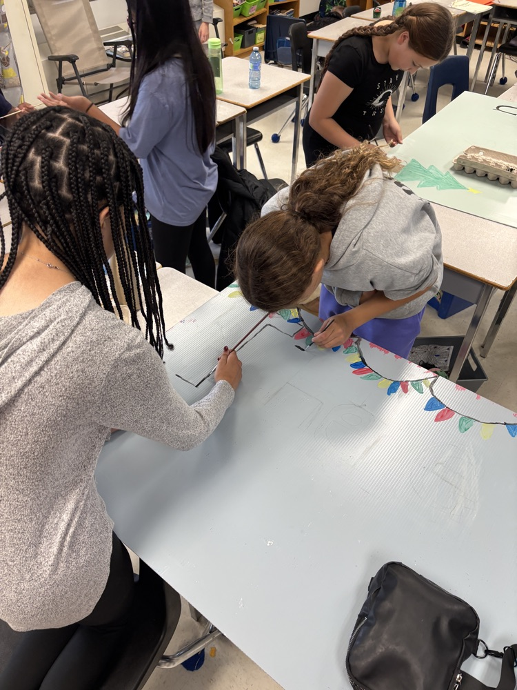 Students painting a poster to advert