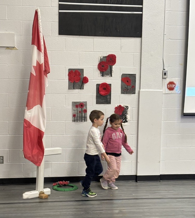2 students from FDK putting a handmade wreath on the cross