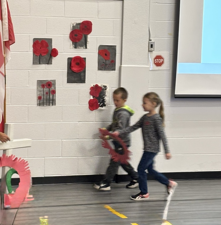 2 young students from Grade 1/2 putting a wreath on the cross