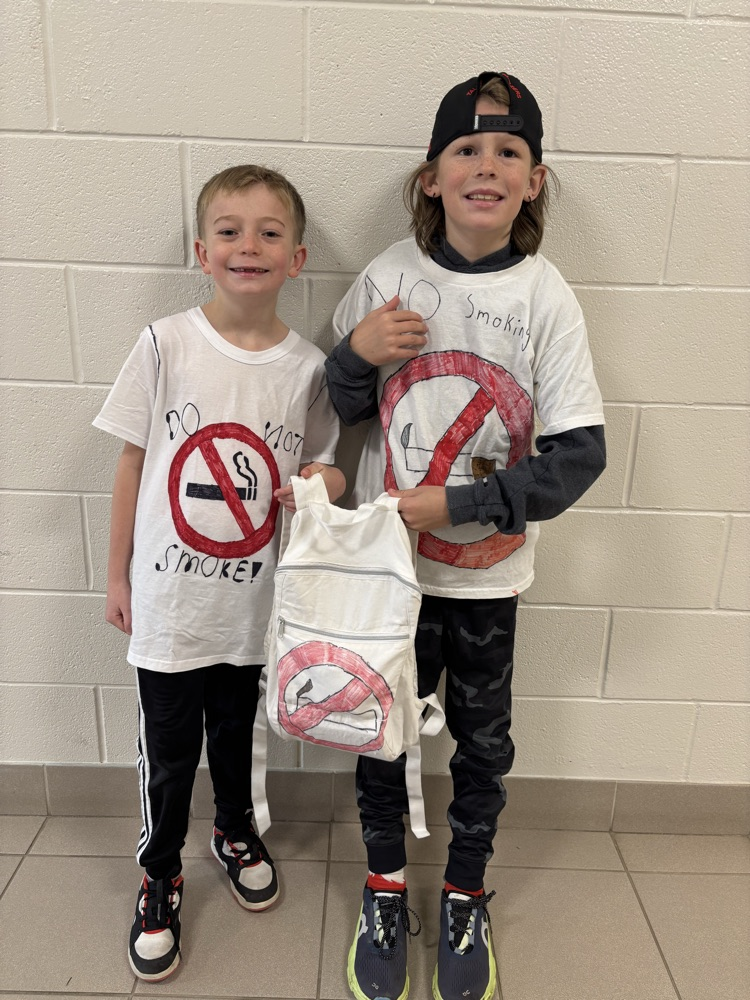two boys smiling at the camera wearing homemade no smoking shirts