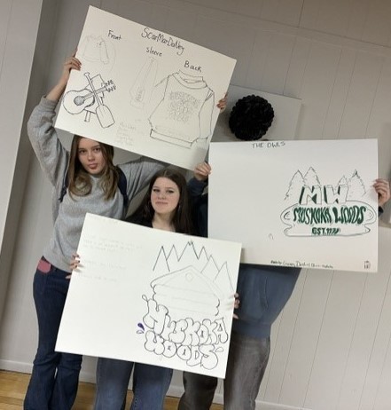 Students holding their Hoodie designs.