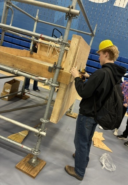 A student working at an interactive, hands-on construction display.