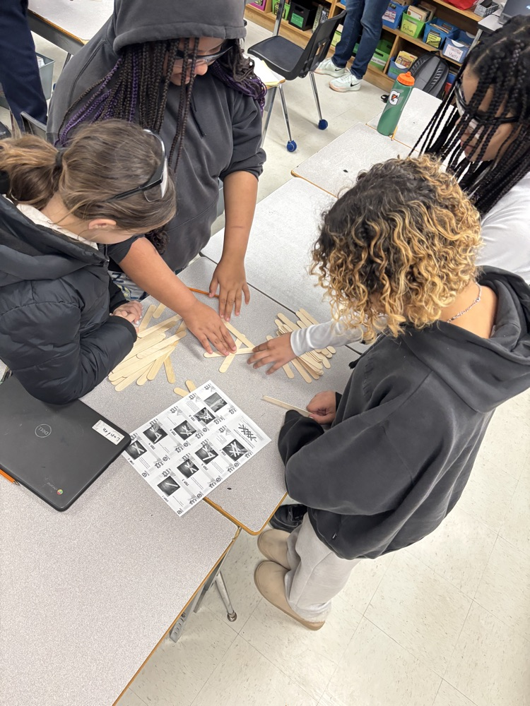 Students working together on a project using popsicle sticks