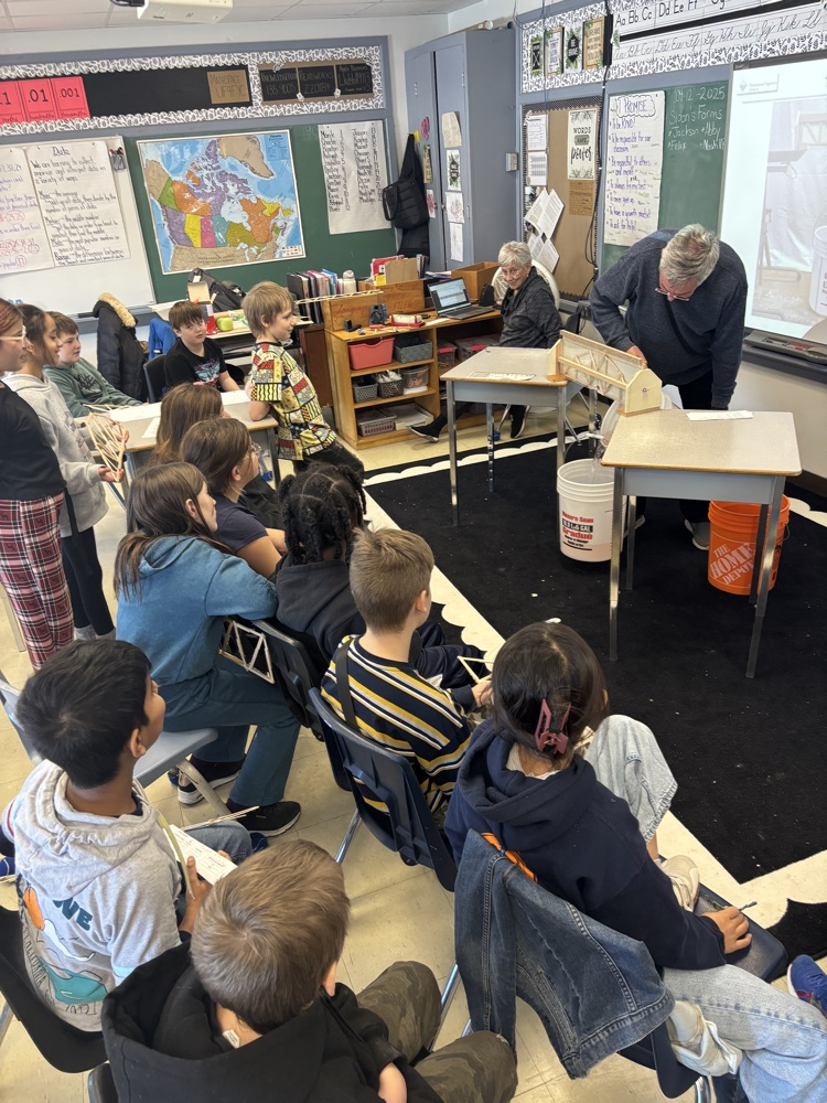 students watching a demonstration of the structural supports involved in bridges
