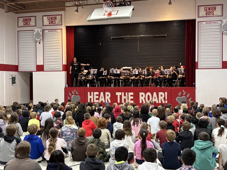 student sitting in the gym watching a band perform