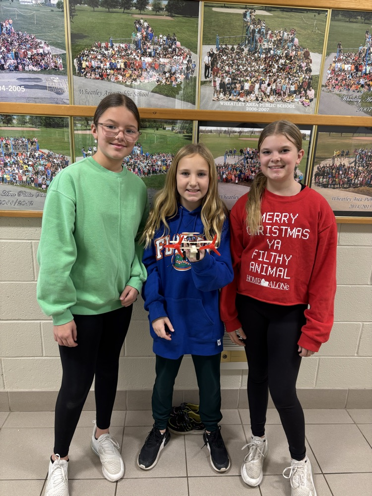 three grade 6 girls with the airplane that they created for science