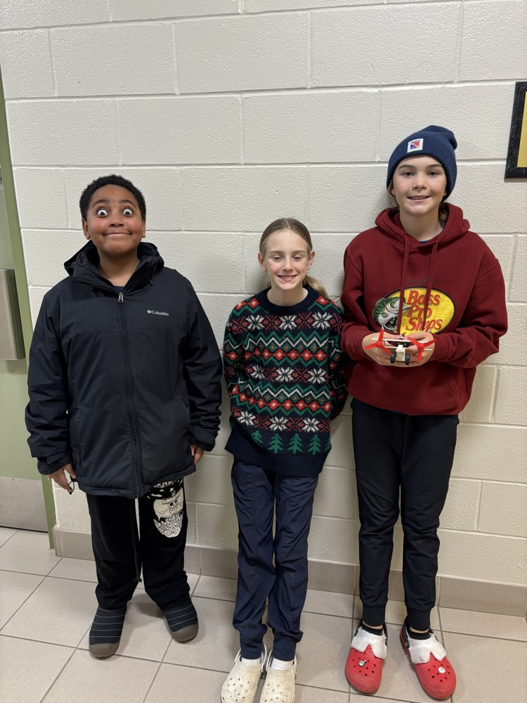 Grade 6 group of student students with an airplane they created for science
