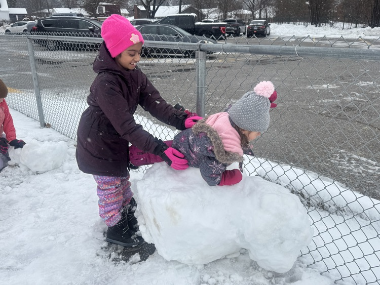 two people playing with a snowball 