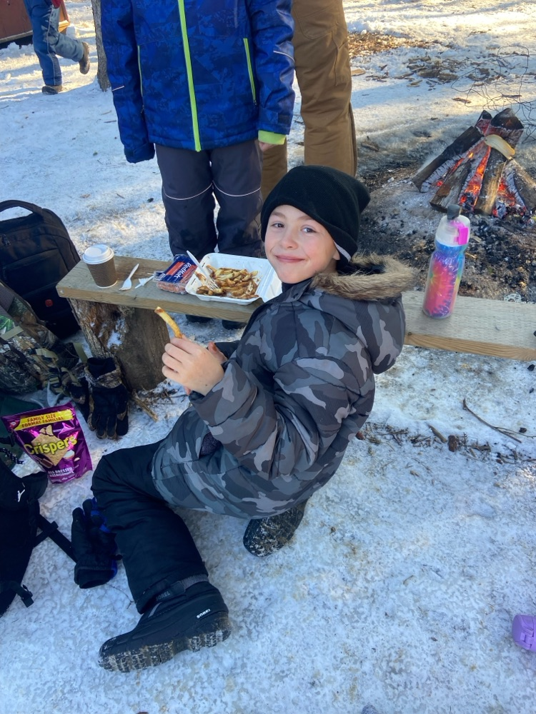 Student sitting around a campfire