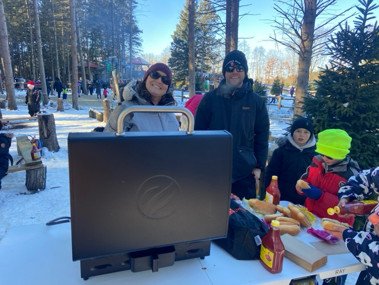 Teachers barbecuing hot dogs at a camp
