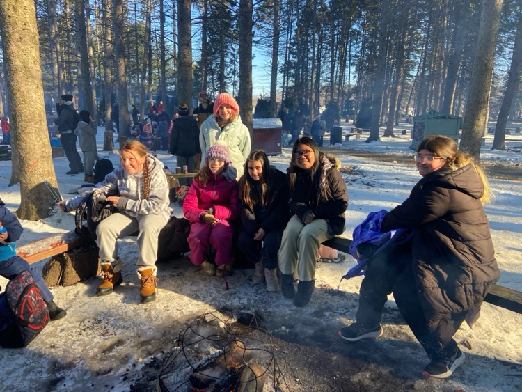 Student sitting around a campfire