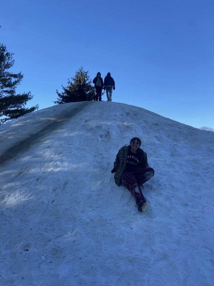 Student sliding down a snow hill