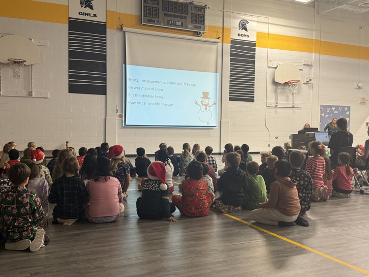 All of the students in the school in the gym singing Christmas carols