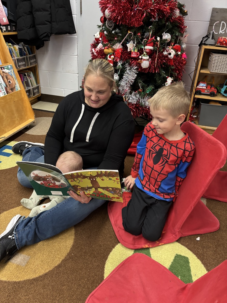 Parent, reading with their children in the kind