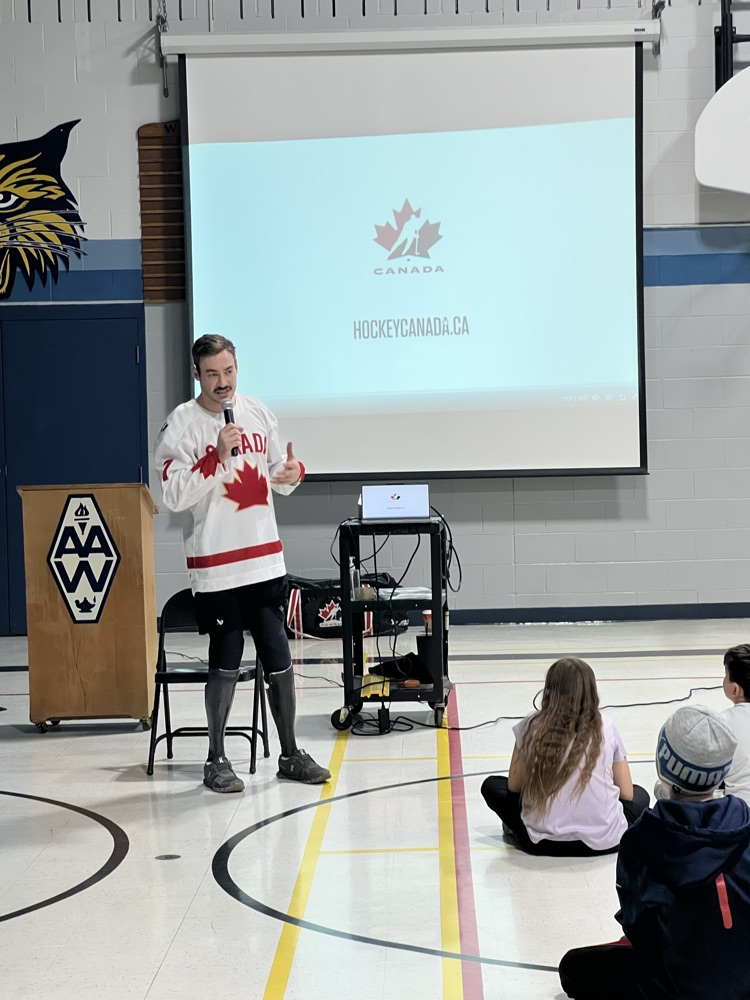 Zach Lavin stands and presents to a group of students 
