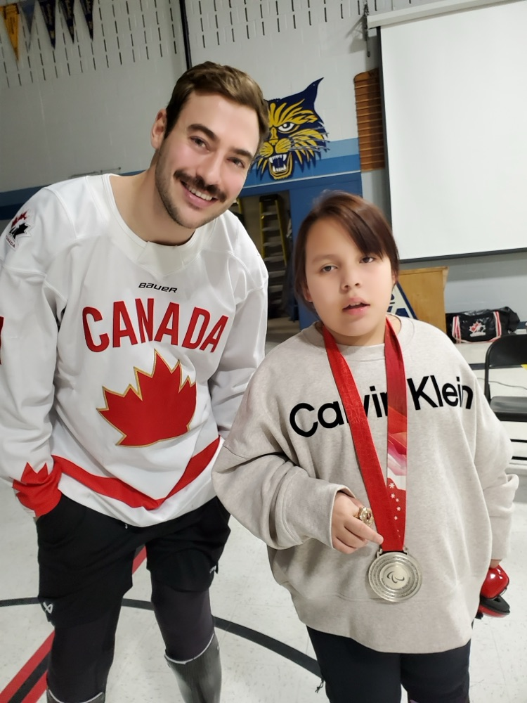 Zach Lavin poses for a photo with a female student wearing his silver medal  