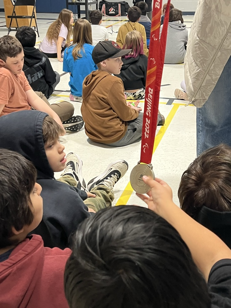 A group of students admire a silver Olympic medal