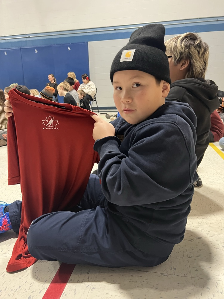 A student holds up a Team Canada shirt