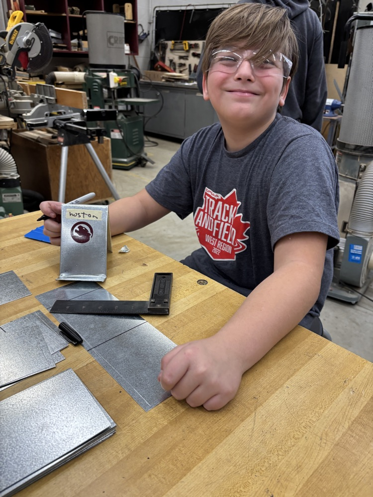 Students bending sheet metal in an auto shop