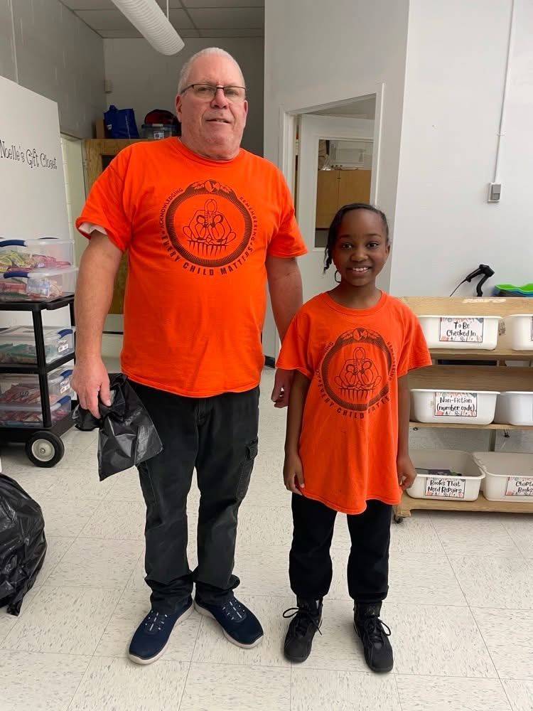 staff member and student wearing orange shirt 