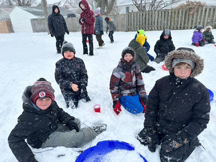 children playing in the snow with a sled