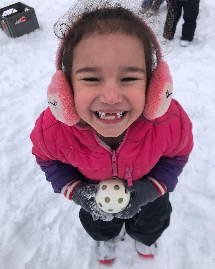 Child playing with a ball in the snow