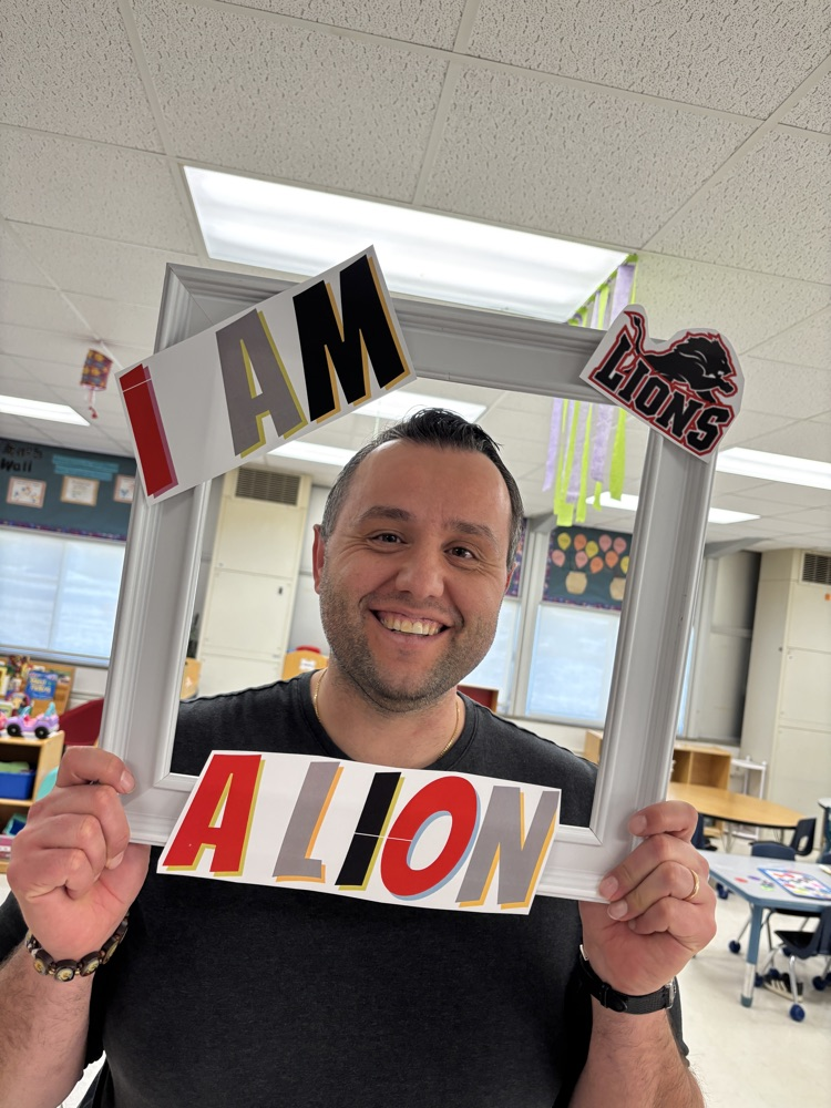teacher holding a picture frame around their face