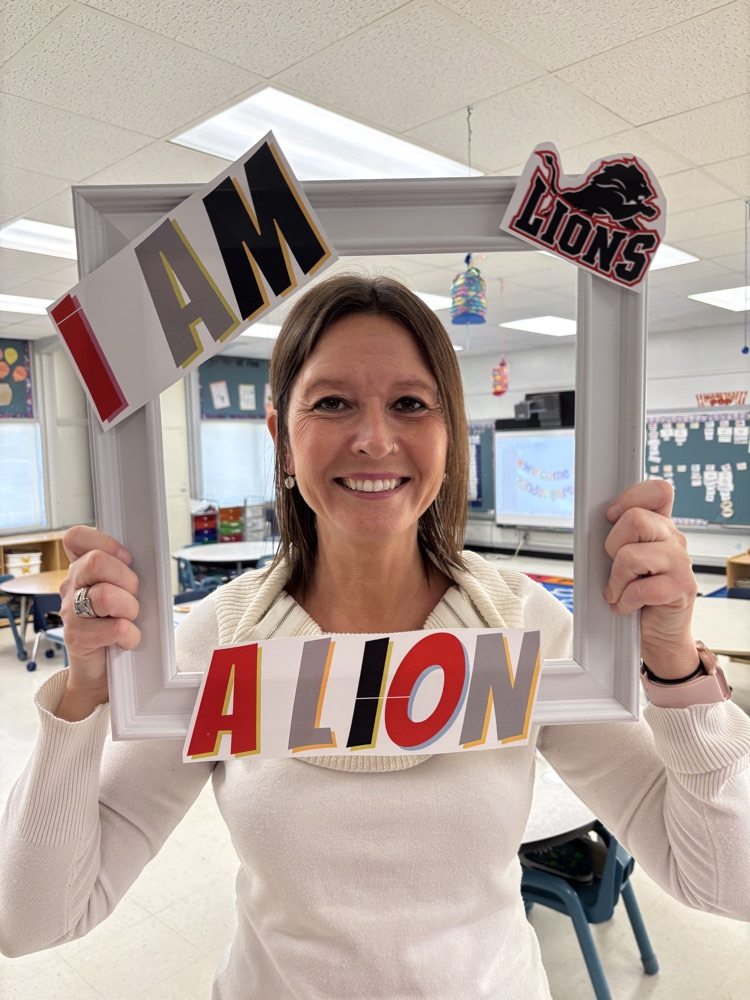 Teacher holding a picture frame around