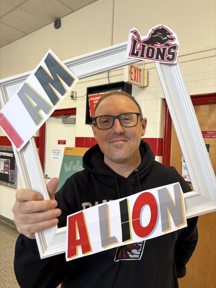 Teacher holding a picture frame around their face