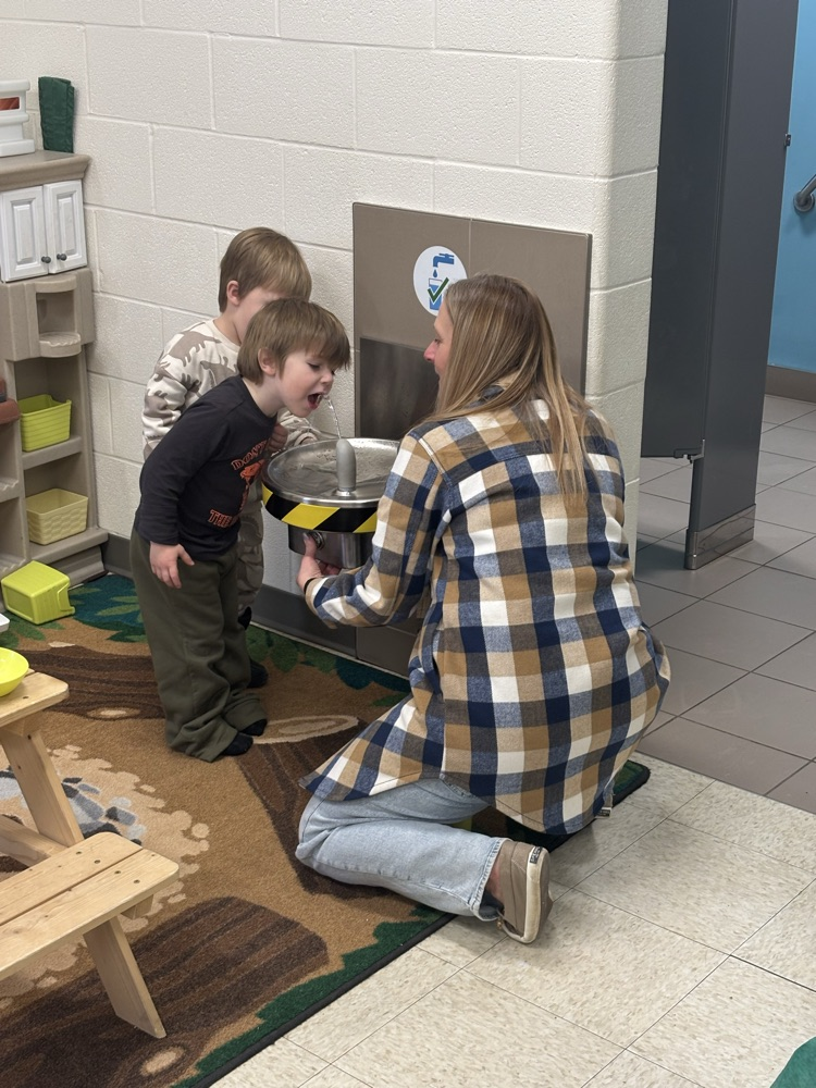 New JK boys learning how to use the water fountain with their teacher